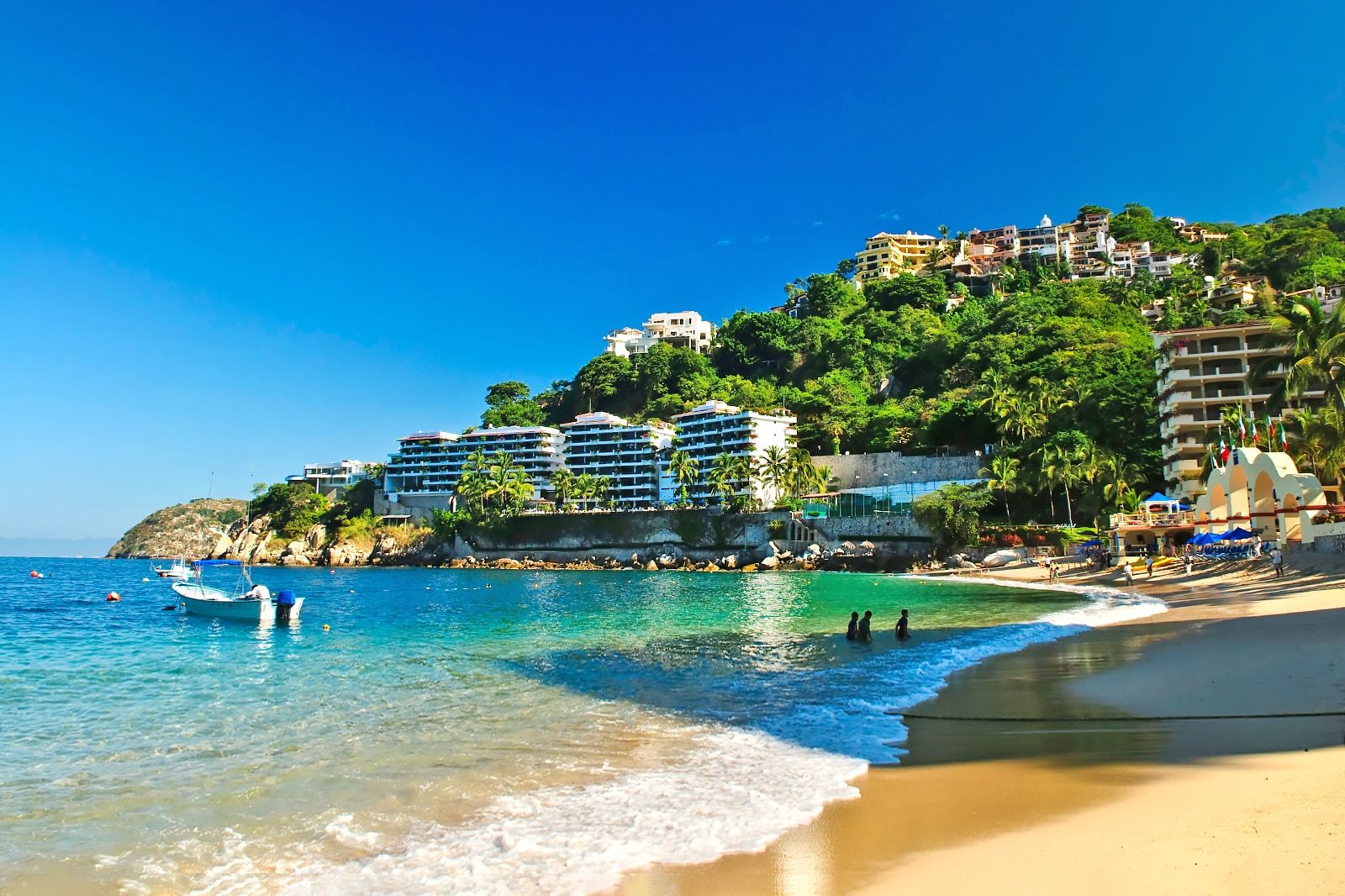 A sheltered cove with clear water and buildings on a hillside
